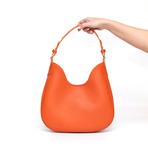 Cloe piccola, borsa da spalla in morbida pelle martellata arancio, design a sacca con accessori metallici color argento, firmata Pianigiani Bags.