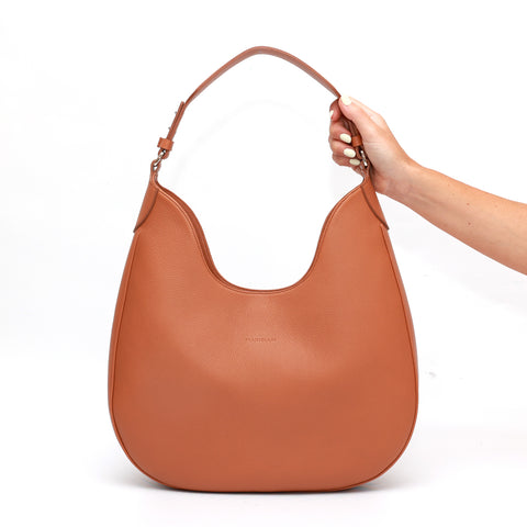 Cloe, borsa da spalla in morbida pelle martellata caramello, design a sacca con accessori metallici color argento, firmata Pianigiani Bags