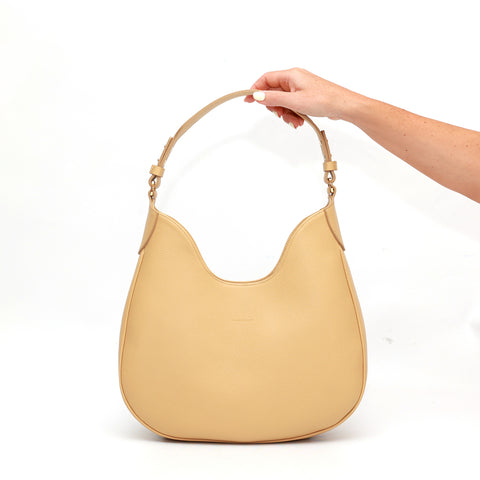 Cloe piccola, borsa da spalla in morbida pelle martellata burro, design a sacca con accessori metallici color oro, firmata Pianigiani Bags.