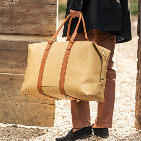 Borsone da viaggio , in pelle martellata giallo burro e rifiniture in cuoio naturale, doppi manici a mano e tracolla regolare removibile. La fodera interna è in cotone beige. Prodotto da Pianigiani handmade leather bags in Italia.