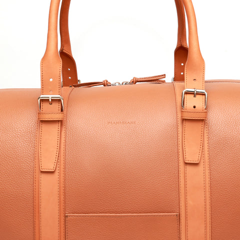 Borsone da viaggio , in pelle martellata marrone caramello e rifiniture in cuoio naturale, doppi manici a mano e tracolla regolare removibile. La fodera interna è in cotone beige. Prodotto da Pianigiani handmade leather bags in Italia.