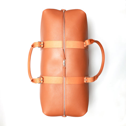 Borsone da viaggio , in pelle martellata marrone caramello e rifiniture in cuoio naturale, doppi manici a mano e tracolla regolare removibile. La fodera interna è in cotone beige. Prodotto da Pianigiani handmade leather bags in Italia.