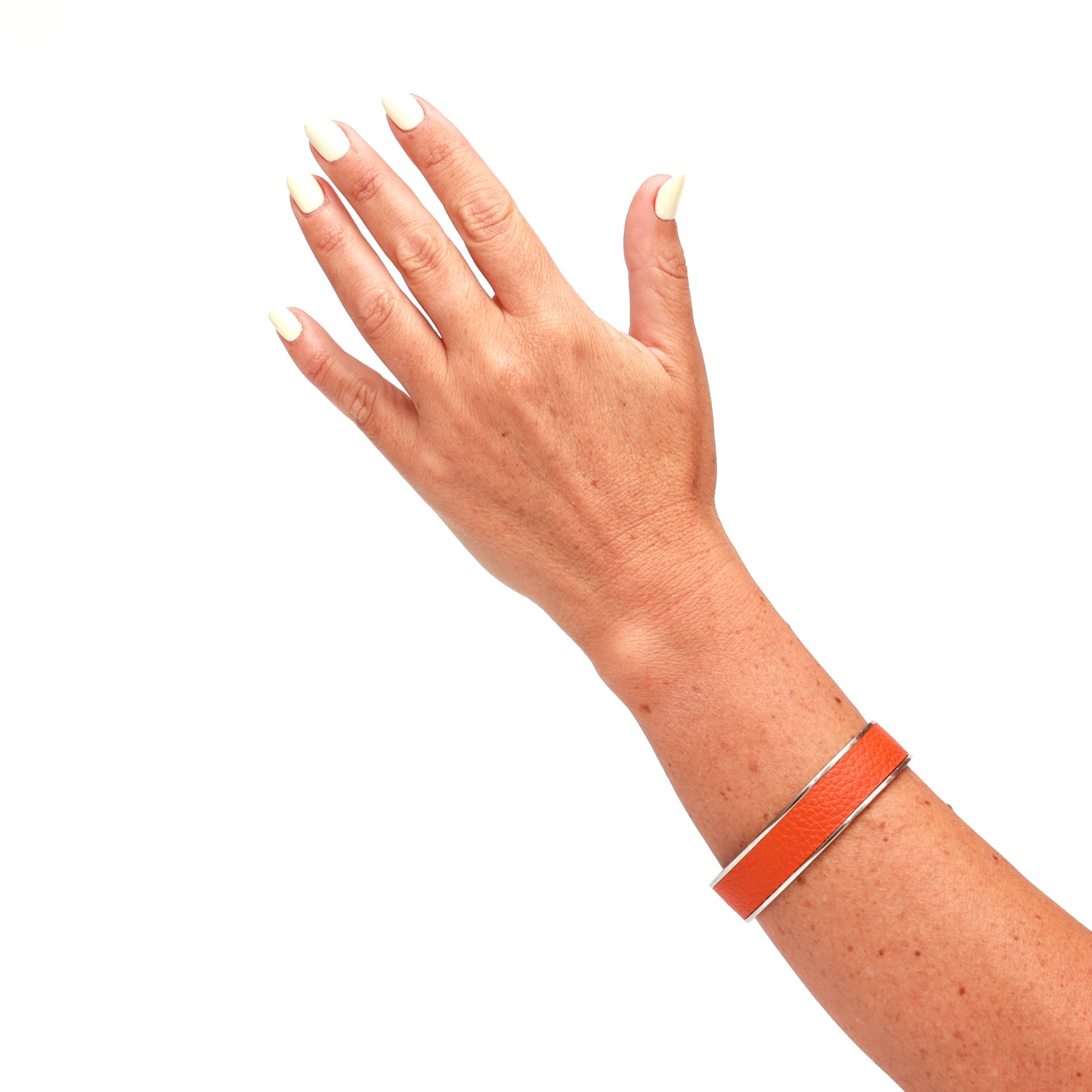 Bracciale rigido in pelle di vitello arancio con finitura color argento lucido. Prodotto presso il laboratorio Pianigiani in Buonconvento (Siena).