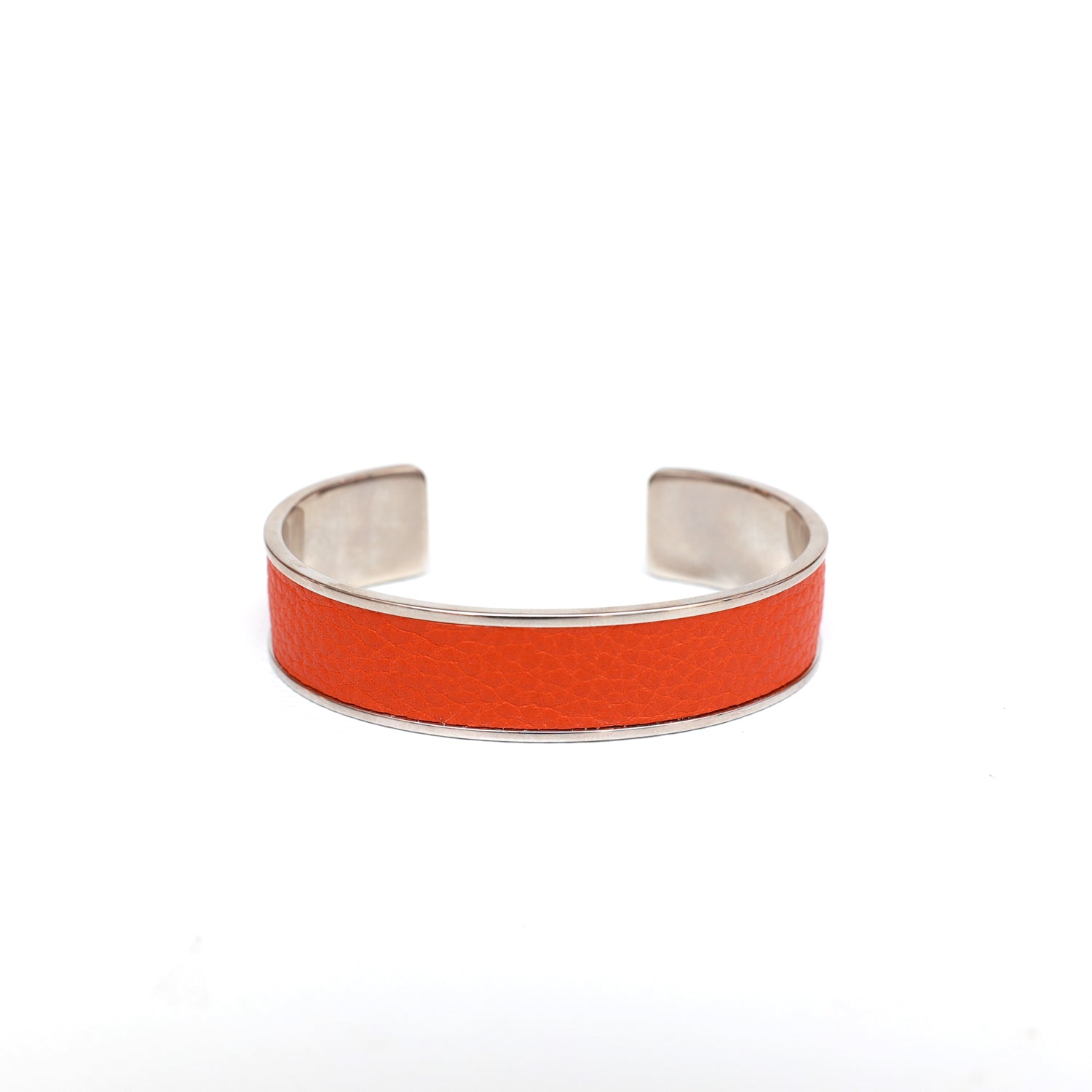 Bracciale rigido in pelle di vitello arancio con finitura color argento lucido. Prodotto presso il laboratorio Pianigiani in Buonconvento (Siena).