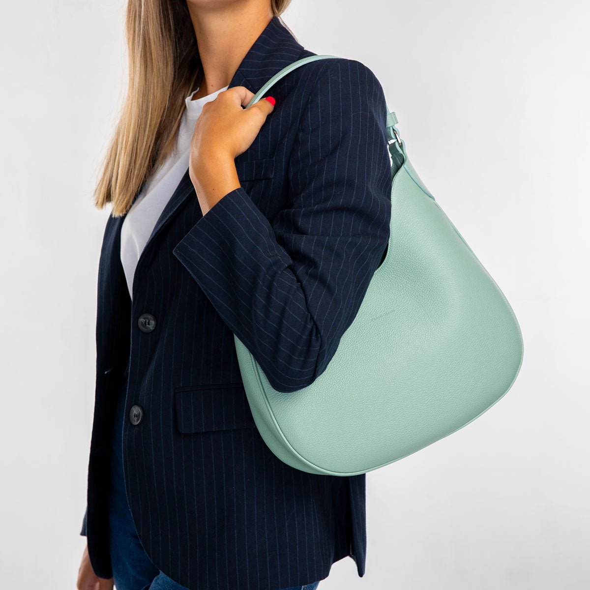 Cloe piccola, borsa da spalla in morbida pelle martellata celeste, design a sacca con accessori metallici color argento, firmata Pianigiani Bags