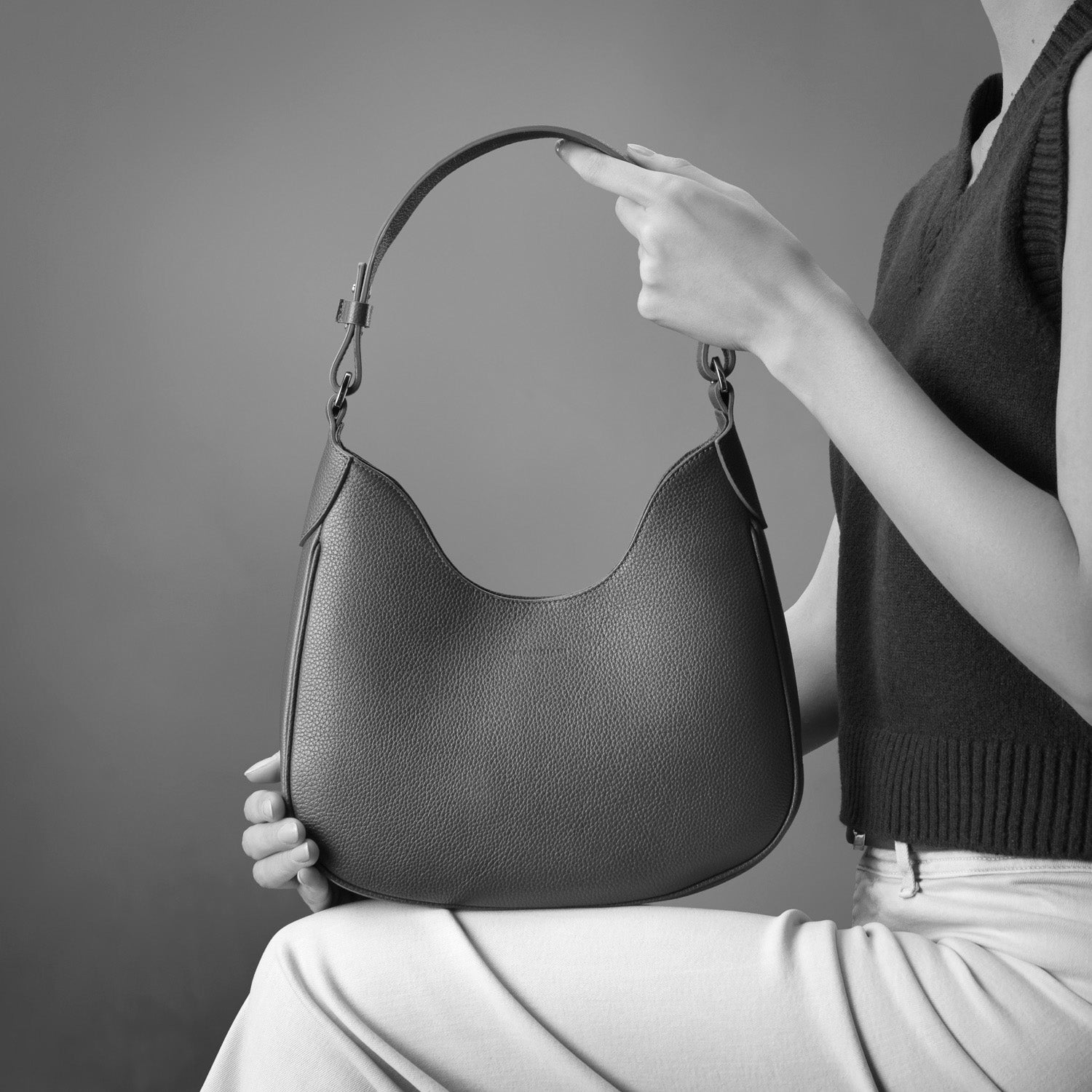 Mini Cloe borsa da spalla in morbida pelle martellata nera, design a sacca con accessori metallici color oro, firmata Pianigiani Bags.
