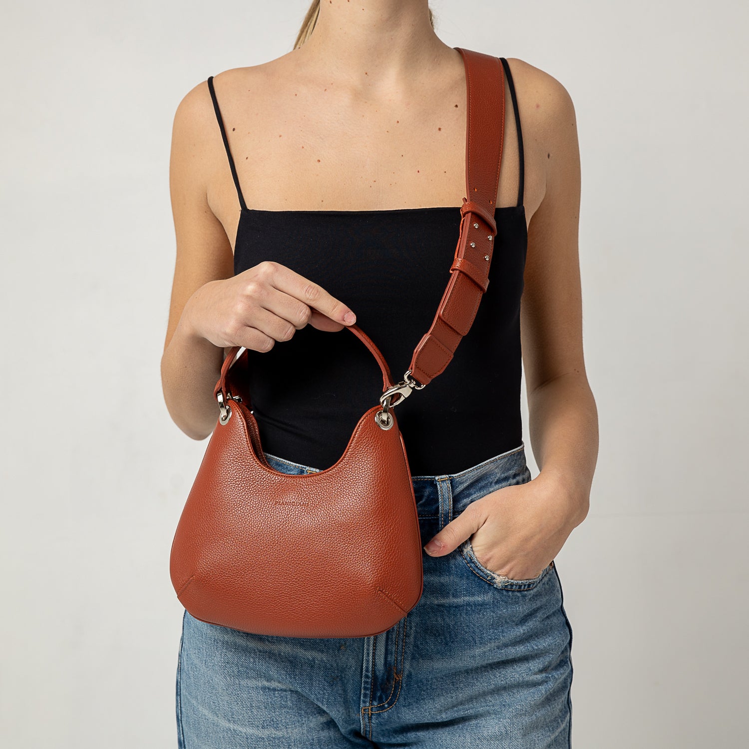 Mini Lou, borsa compatta da donna a tracolla, realizzata in pelle martellata color ruggine, con lavorazione artigianale firmata Pianigiani Bags.