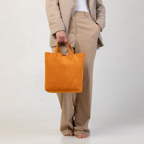 Soft 2.4 piccola, borsa da donna in pelle scamosciata arancio, realizzata artigianalmente da Pianigiani Bags.