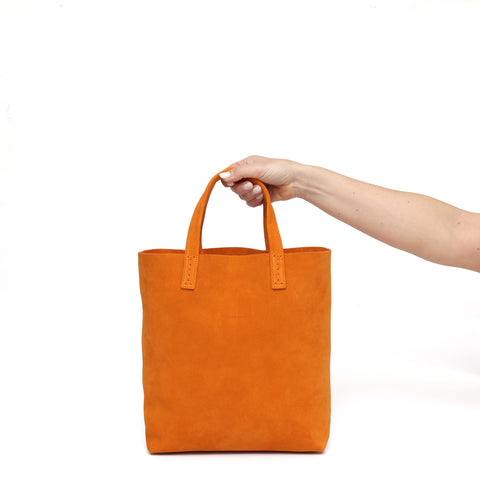 Soft 2.4 piccola, borsa da donna in pelle scamosciata arancio, realizzata artigianalmente da Pianigiani Bags.
