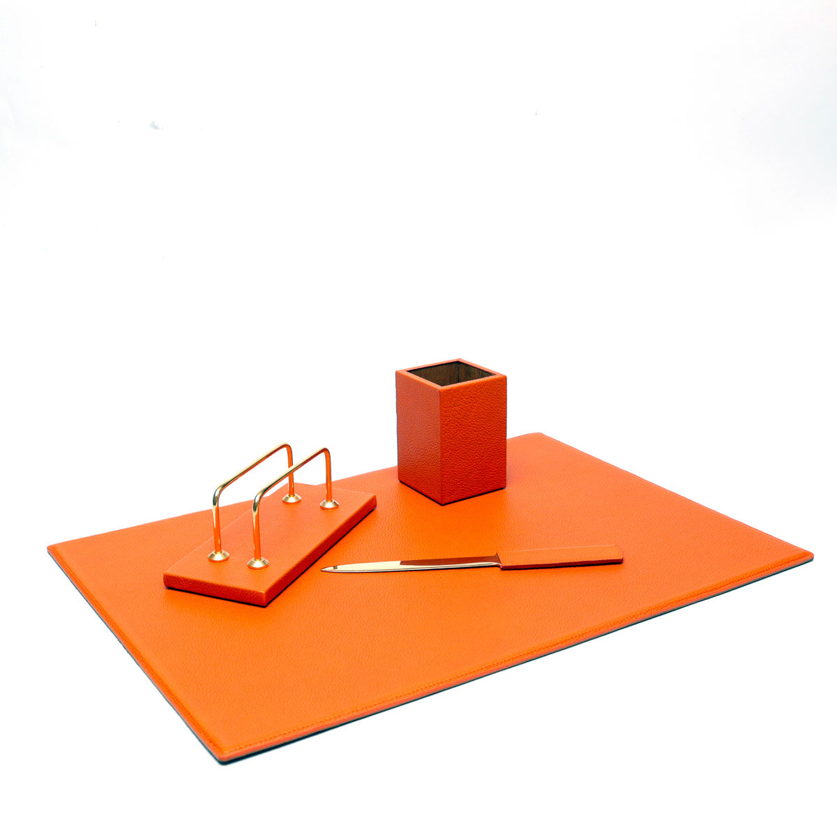 Set da scrivania in pelle arancione formato da sottomano,porta penne, taglia carte e porta lettere,prodotto da Pianigiani bags.